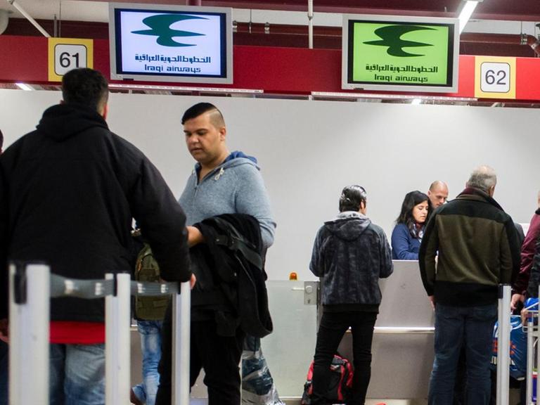 Reisende und Flüchtlinge an Check-In-Schaltern in Berlin-Tegel eines Fluges der Iraqi Airways nach Erbil.
