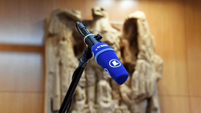 Ein Mikrofon des SWR im Gerichtssaal des Bundesverfassungsgerichts. Im Hintergrund ist der Bundesadler zu sehen.