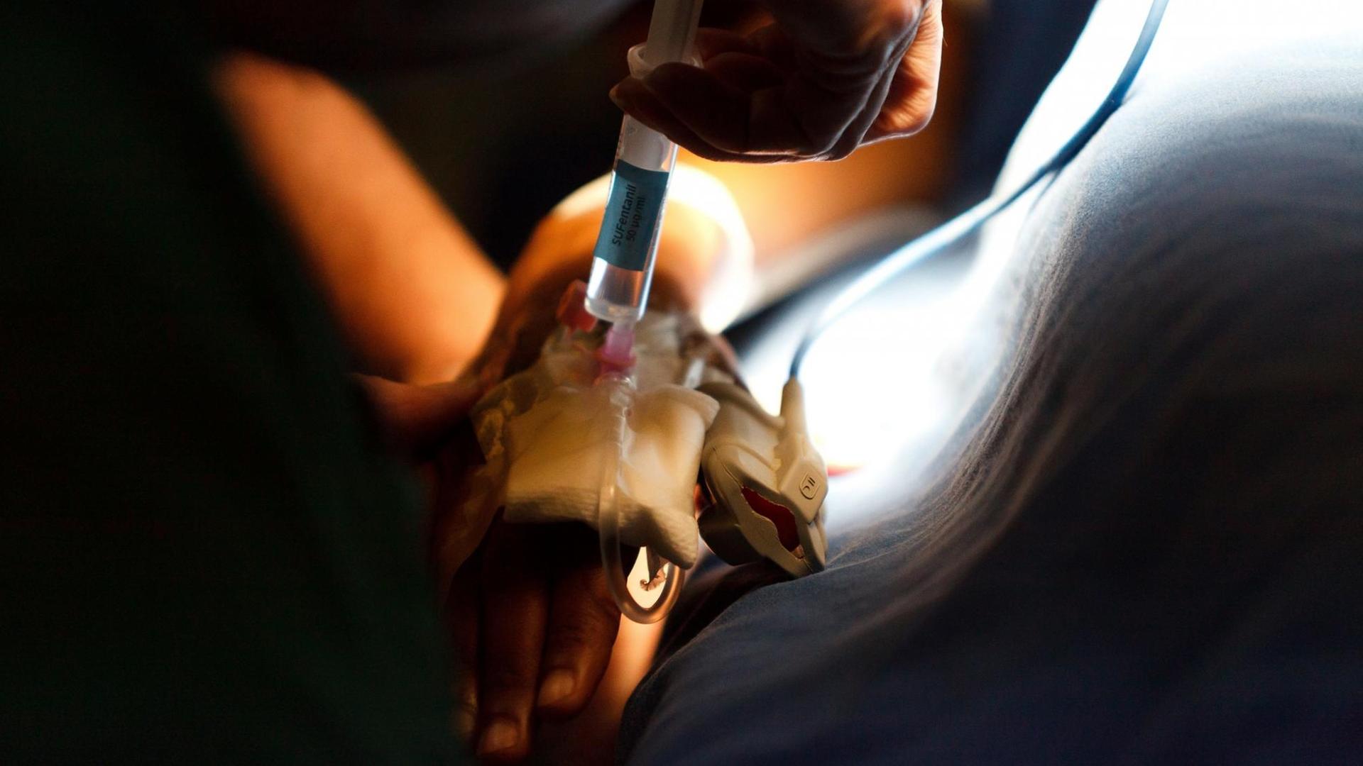 Herzklappenoperation: Die Narkose ist eingeleitet, alle Zugänge sind gelegt. Der Patient bekommt über einen Zugang in der Vene ein Schmerzmittel gespritzt. Herzklappenoperation: Die Narkose ist eingeleitet, alle Zugänge sind gelegt. Der Patient bekommt über einen Zugang in der Vene ein Schmerzmittel gespritzt.