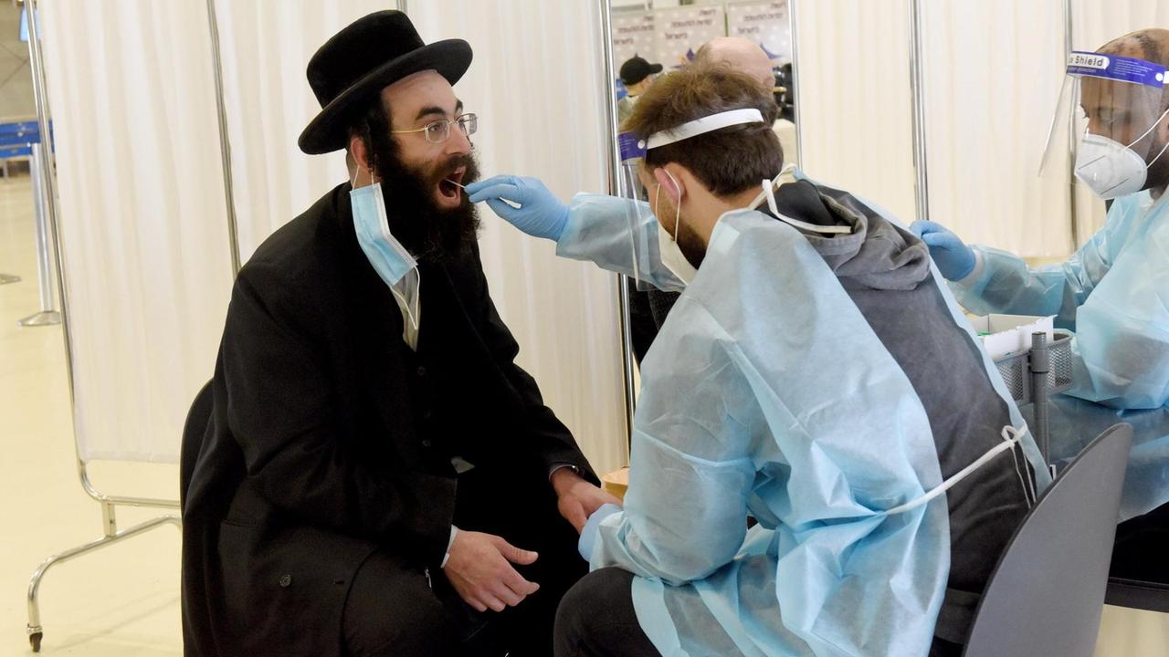 Ein Ultra-Orthodoxe Jude wird auf COVID-19 getestet nachdem er am Ben Gurion Flughafen in Tel Aviv angekommen ist. Alle Fluggäste werde in einem Testzentrum getestet. Israel,14. März 2021. Ein Ultra-Orthodoxe Jude wird auf COVID-19 getestet nachdem er am Ben Gurion Flughafen in Tel Aviv angekommen ist. Alle Fluggäste werde in einem Testzentrum getestet. Israel,14. März 2021.
