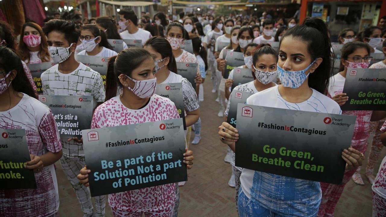Indian fashion students, wearing anti-pollution masks, hold placards as they gather to participate in a march through a market place for creating awareness on air pollution in New Delhi, India, Friday, Nov. 2, 2018. With air quality reduced to "very severe" in the Indian capital region, authorities are bracing for a major Hindu festival featuring massive fireworks that threatens to cloak New Delhi with more toxic smog and dust. (AP Photo/Altaf Qadri) |