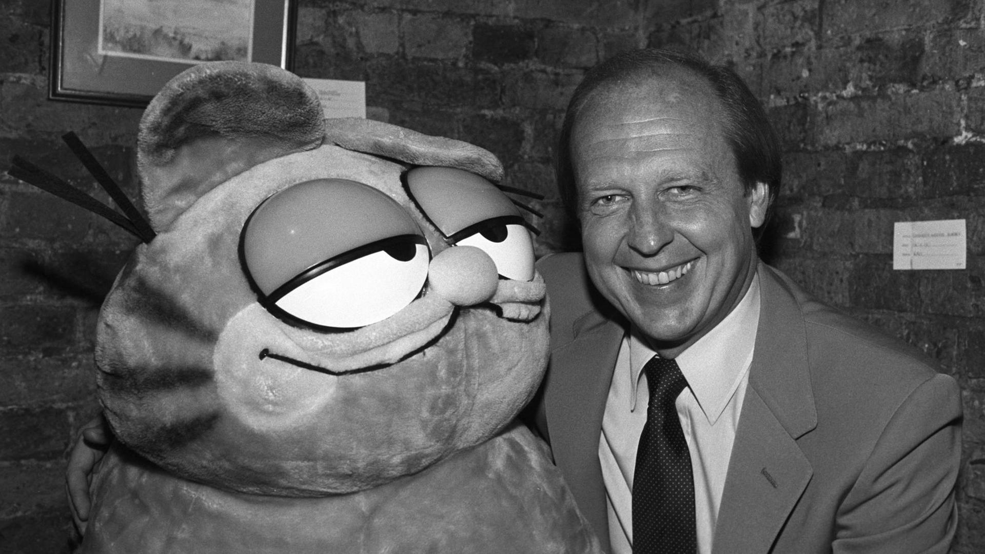 Eine schwarz-weiß-Aufnahme zeigt den amerikanischen Karikaturist Jim Davis mit seiner berühmtesten Kreation Garfield am 25. Oktober 1983. Eine schwarz-weiß-Aufnahme zeigt den amerikanischen Karikaturist Jim Davis mit seiner berühmtesten Kreation Garfield am 25. Oktober 1983.