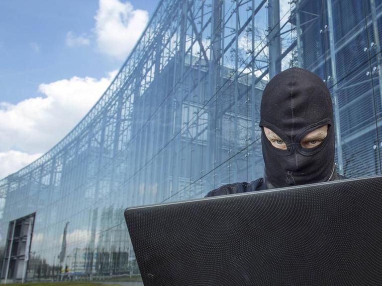 Ein Hacker vor dem Neven DuMont Haus in Köln.
