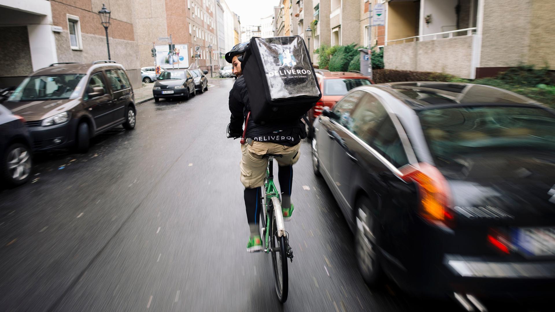Ein Fahrradkurier ist im Auftrag der Firma Deliveroo unterwegs. Deliveroo beliefert Kunden mit Essen aus Restaurants. Ein Fahrradkurier ist im Auftrag der Firma Deliveroo unterwegs. Deliveroo beliefert Kunden mit Essen aus Restaurants.