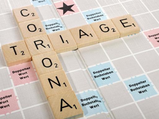 Buchstabenspiel "Scrabble": Buchstaben bilden die Worte "Corona" und "Triage" auf dem "Scrabble"-Spielbrett.