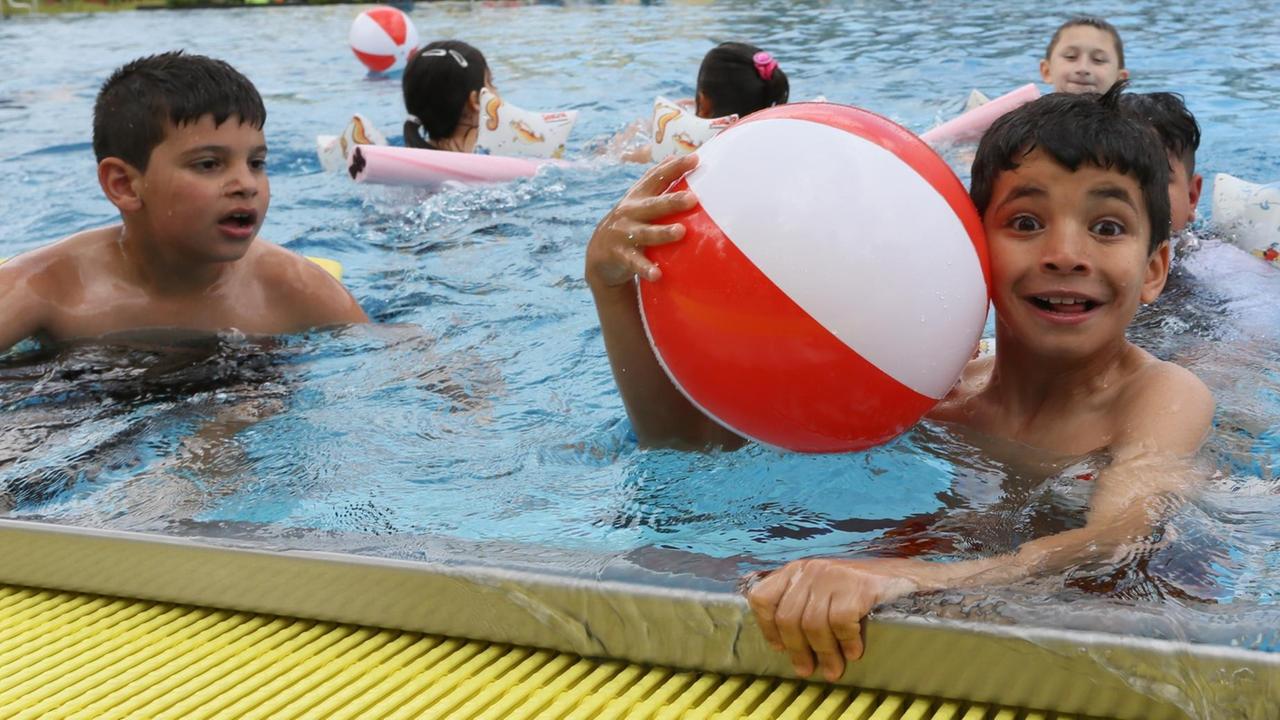 Zweitklässler von zwei Neuköllner Schulen rutschen am 03.06.2015 im Kombibad in Gropiusstadt in Berlin eine Wasserrutsche hinunter. Rund 70 Kinder eröffneten zuvor mit einem Sprung in Wasser das Pilotprojekt "Neuköllner Schwimmbär" zum Angstabbau vor Wasser und einer optimalen Vorbereitung auf dem Schwimmunterricht in der Schule. Zweitklässler von zwei Neuköllner Schulen rutschen am 03.06.2015 im Kombibad in Gropiusstadt in Berlin eine Wasserrutsche hinunter. Rund 70 Kinder eröffneten zuvor mit einem Sprung in Wasser das Pilotprojekt "Neuköllner Schwimmbär" zum Angstabbau vor Wasser und einer optimalen Vorbereitung auf dem Schwimmunterricht in der Schule.