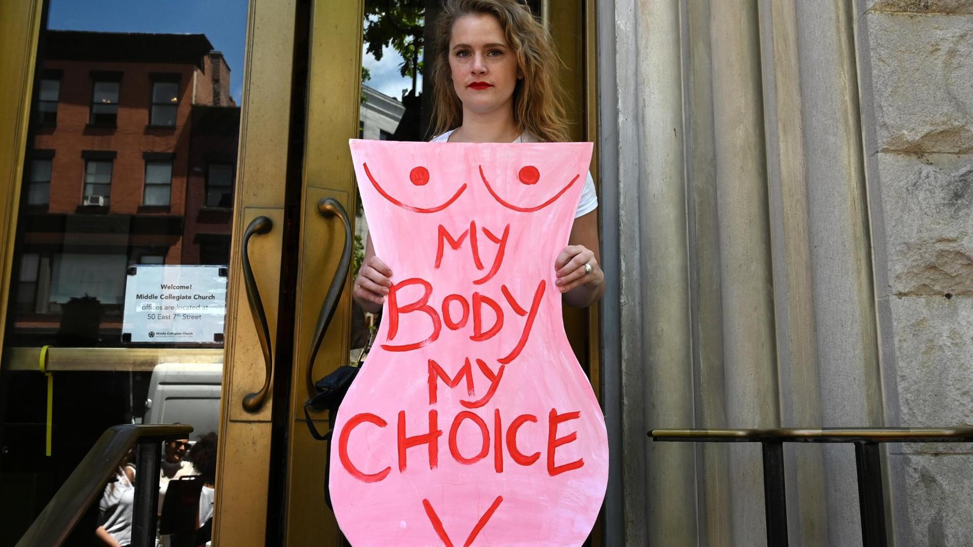 Eine Aktivistin hält bei einer Demonstration für legale Abtreibungen einen Karton in Form eines Frauenkörpers in deie Höhe, auf dem steht "Mein Körper, meine Entscheidung".