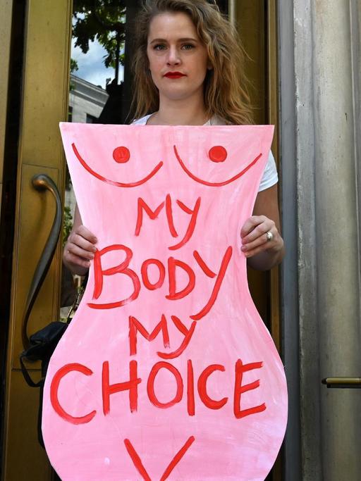 Eine Aktivistin hält bei einer Demonstration für legale Abtreibungen einen Karton in Form eines Frauenkörpers in deie Höhe, auf dem steht "Mein Körper, meine Entscheidung".