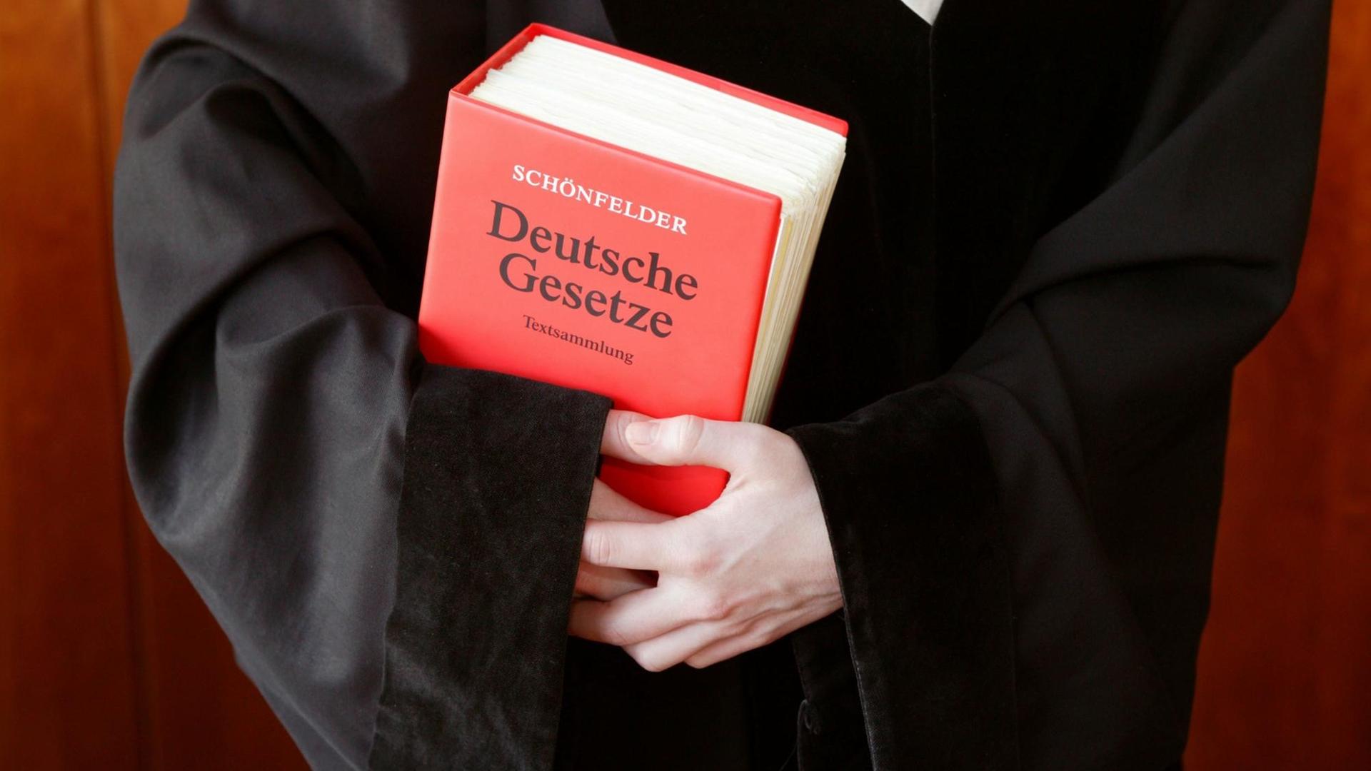 Richterin / Staatsanwältin / Anwältin in einer Robe mit dem Schönfelder Gesetzbuch - Deutsche Gesetze Richterin / Staatsanwältin / Anwältin in einer Robe mit dem Schönfelder Gesetzbuch - Deutsche Gesetze