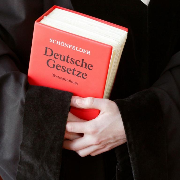 Richterin / Staatsanwältin / Anwältin in einer Robe mit dem Schönfelder Gesetzbuch - Deutsche Gesetze