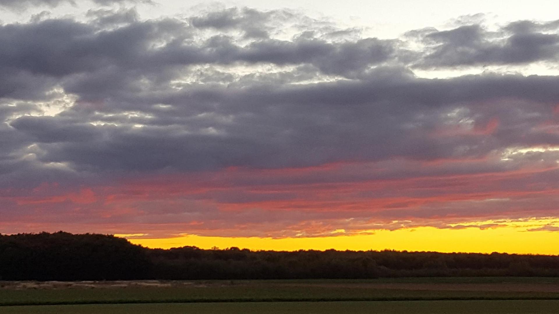 Wolken werden durch die untergehende Sonne rot gefärbt. Wolken werden durch die untergehende Sonne rot gefärbt.