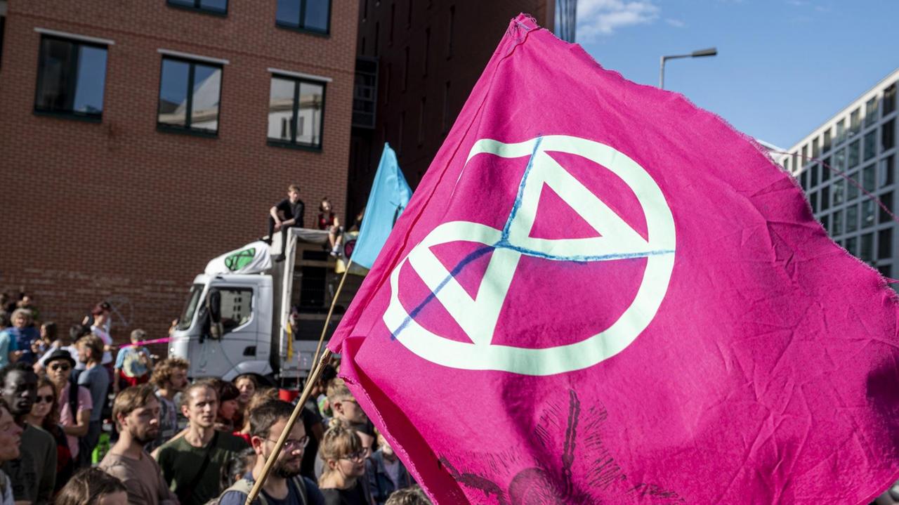 Eine Flagge mit dem Logo der Klimabewegung "Extinction Rebellion" weht im Wind vor dem Bundesministerium für Umwelt. Eine Flagge mit dem Logo der Klimabewegung "Extinction Rebellion" weht im Wind vor dem Bundesministerium für Umwelt.