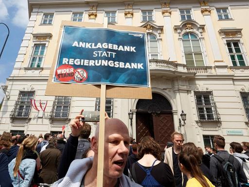 Ein Demonstrant in Wien fordert eine strafrechtliche Verfolgung von Vizekanzler Heinz-Christian Strache nach dessen Rücktritt. Ein Mann hält während einer Demo in Wien ein Plakat mit der Aufschrift Anklagebank statt Regierungsbank in die Höhe. Auf dem Foto sind die Porträts von HC Strache und Sebastian Kurz zu sehen.
