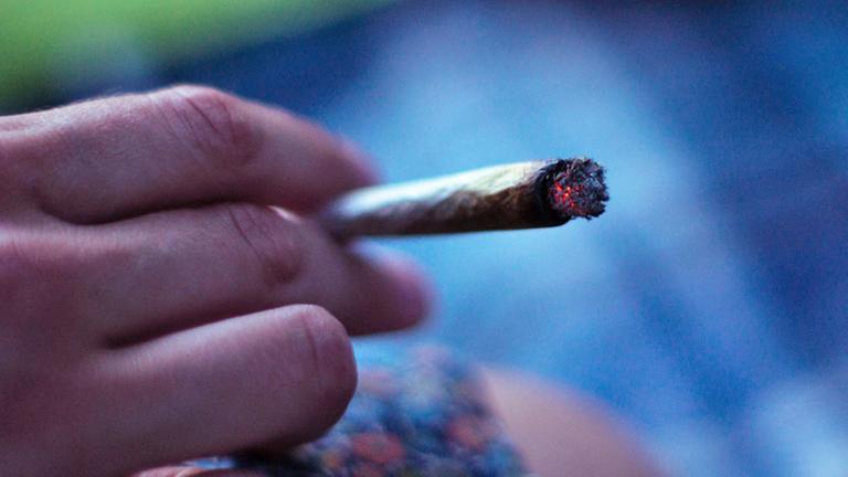 Eine Hand hält einen Joint. Eine Hand hält einen Joint.