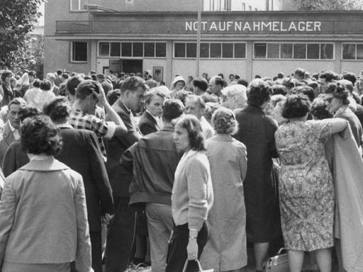 Der Flüchtlingsansturm auf das Notaufnahmelager Berlin-Marienfelde wurde am Montagvormittag, 14.08.1961, immer größer. Tausende von Neuangekommenen, die sich dort registrieren lassen wollten, warteten vor dem Eingang des Notaufnahmelagers. Sie wurden schubweise eingelassen. Die Aufnahmebehörden waren dem Ansturm nicht mehr gewachsen. Die Flüchtlinge wurden erneut aufgefordert, in den nächsten Tagen wiederzukommen.