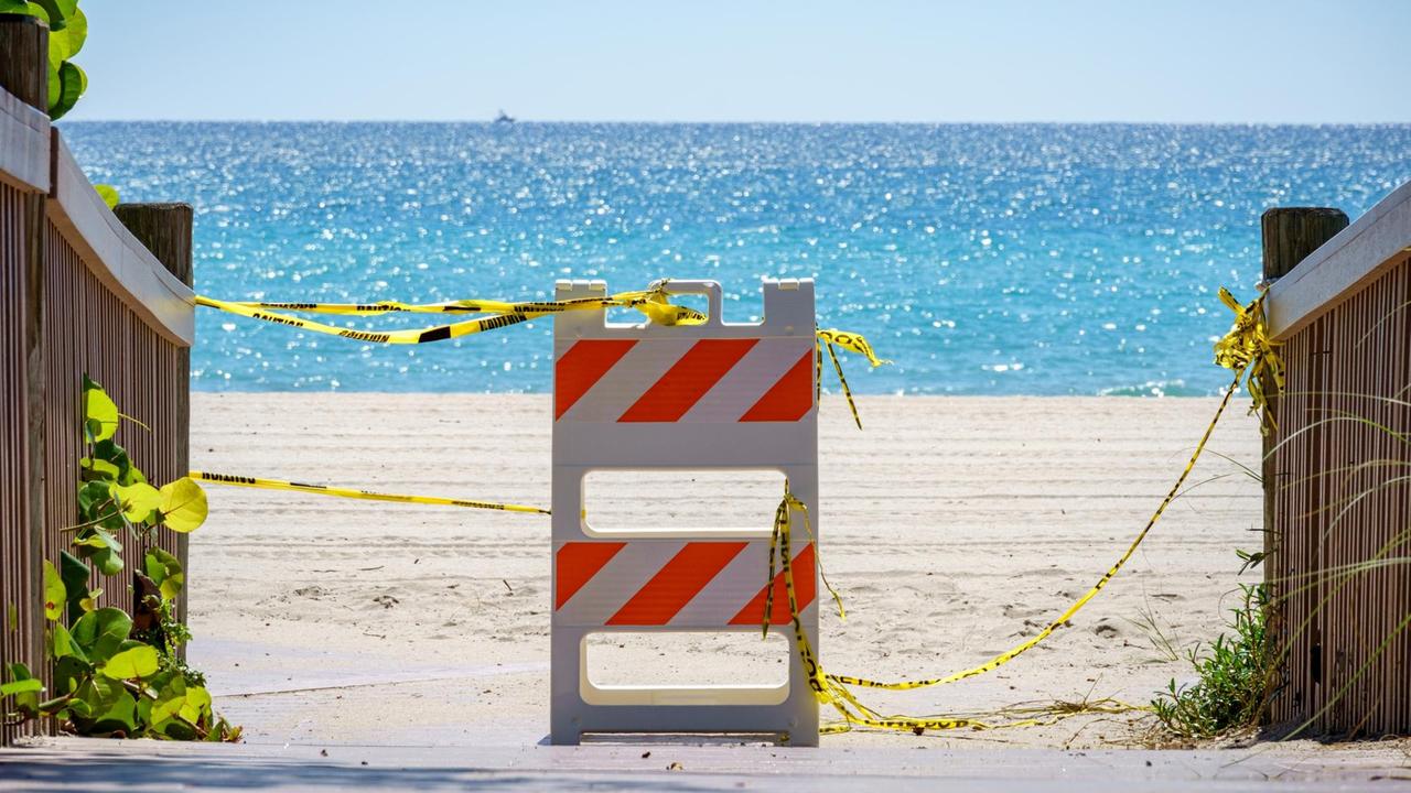 Eine Barriere mit Bändern vor Sandstrand und Meer. Eine Barriere mit Bändern vor Sandstrand und Meer.