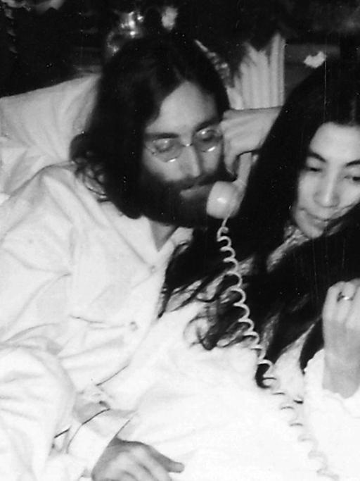 John Lennon und Yoko Ono liegen in einem Hotelbett und telefonieren