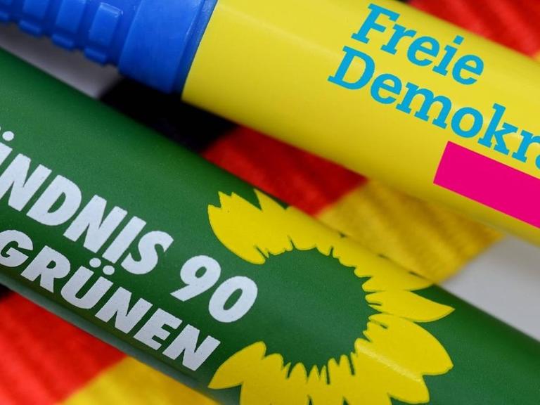 Kugelschreiber der Parteien CDU/CSU, FDP und Bündnis 90 die Grünen liegen auf einer Deutschlandfahne