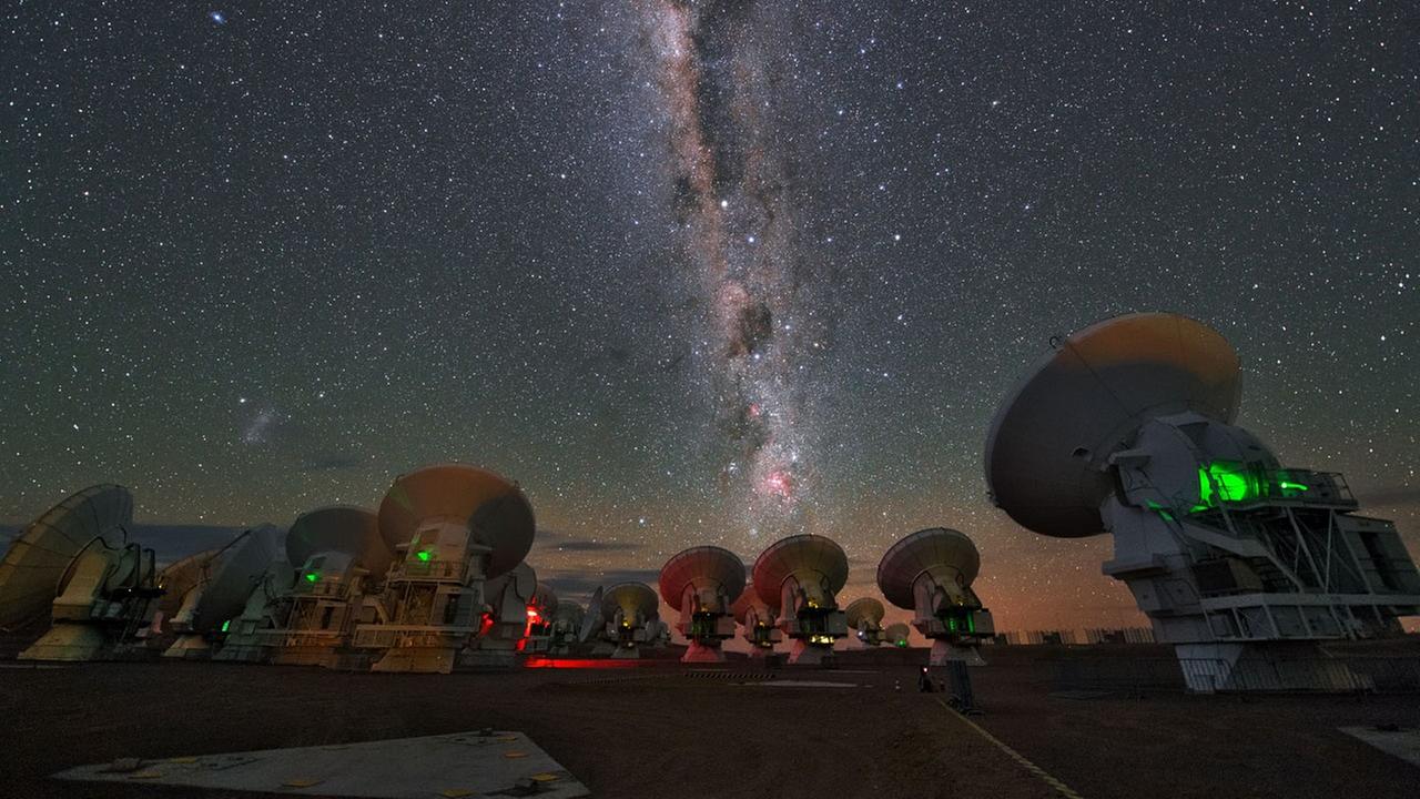 Mehrere Antennen des Atacama Large Millimeter/Submillimeter Array im Norden Chiles. Darüber die Milchstraße.