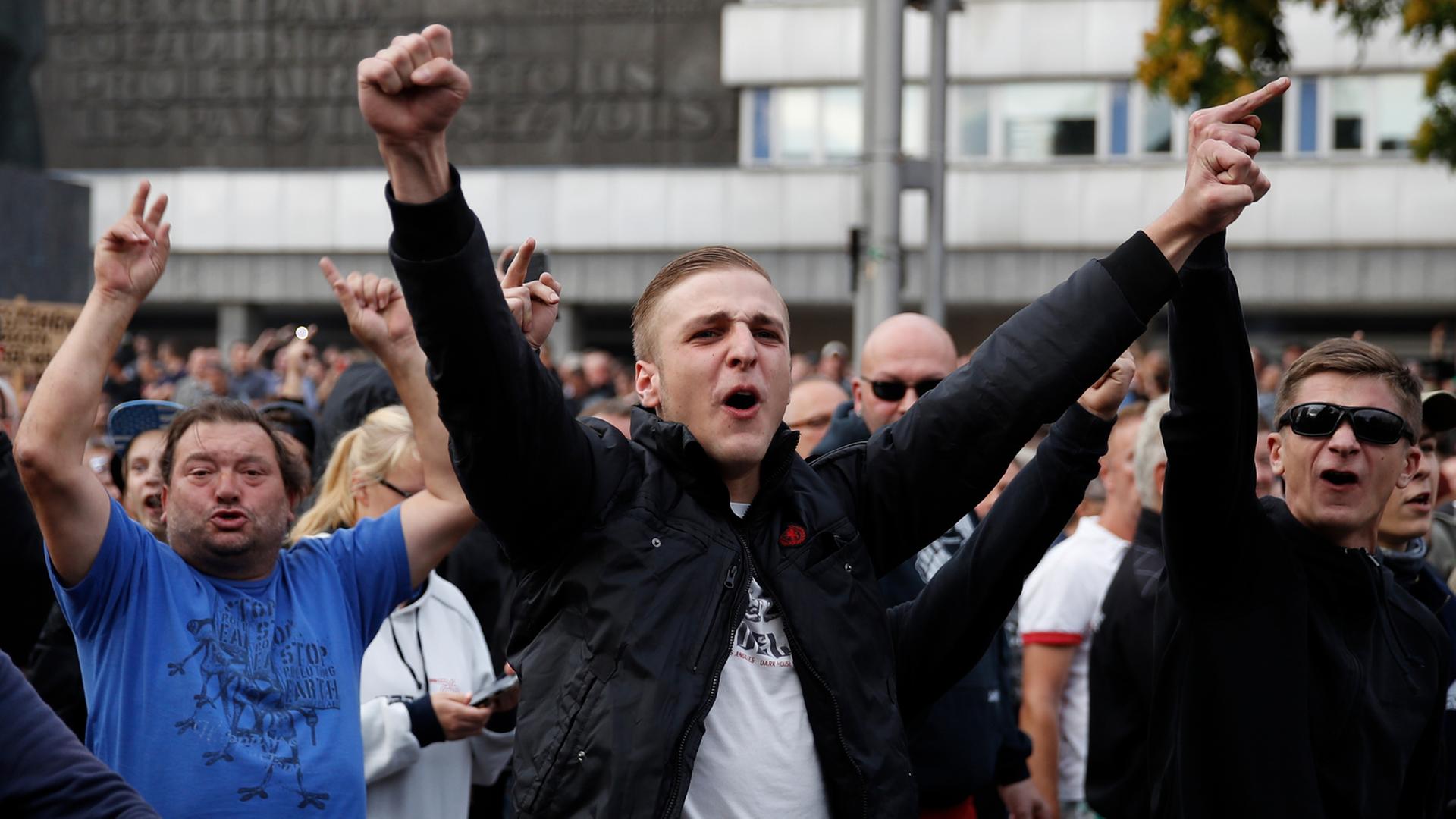 Rechte Demonstranten strecken wutentbrannt ihre Arme in die Höhe. Rechte Demonstranten strecken wutentbrannt ihre Arme in die Höhe.