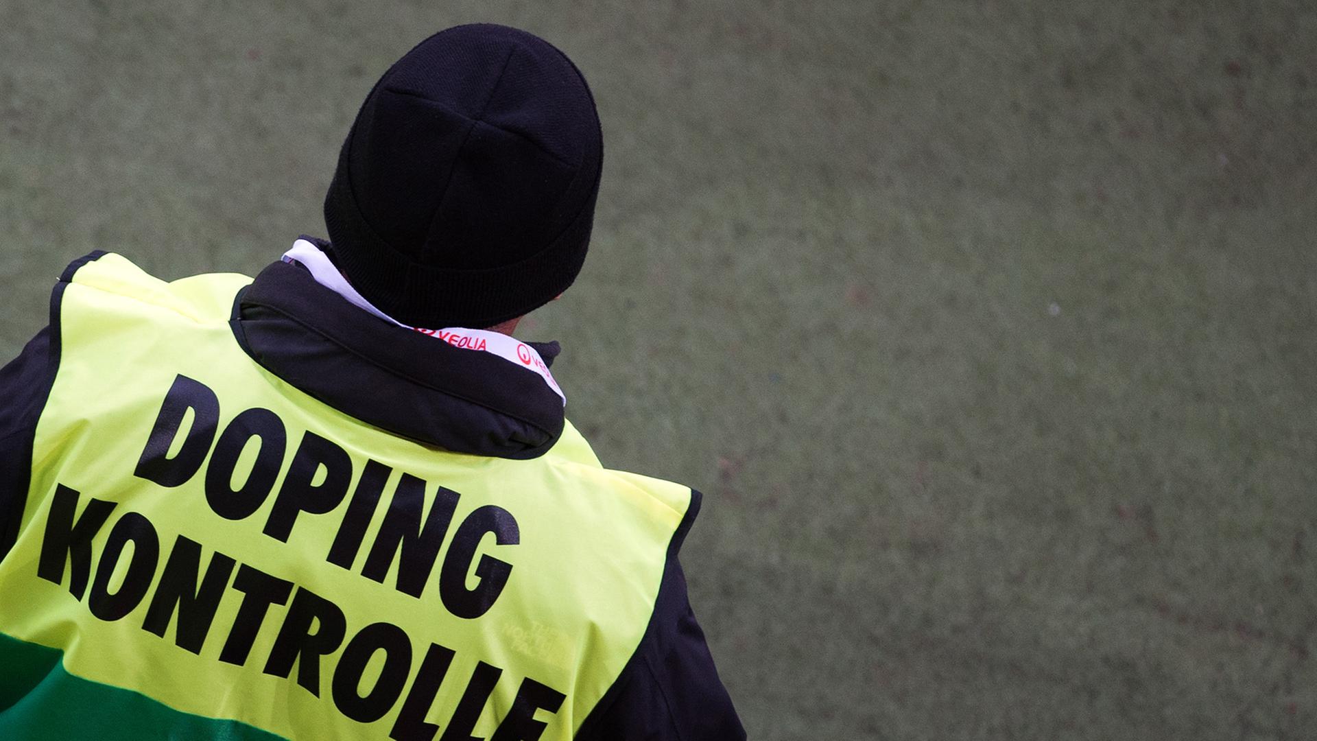 Ein Dopingkontrolleur von hinten mit gelb-grüner Jacke und der Aufschrift "Dopingkontrolle". Ein Dopingkontrolleur von hinten mit gelb-grüner Jacke und der Aufschrift "Dopingkontrolle".