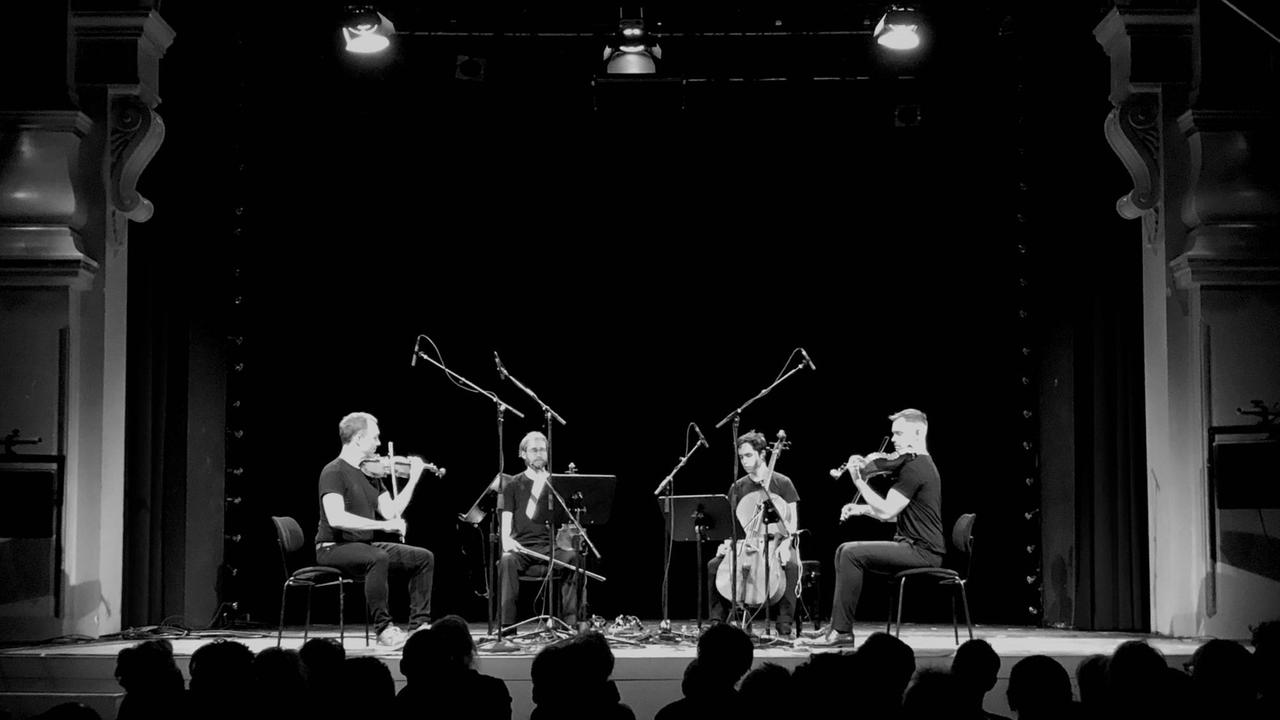 Das Quartett sitzt auf der Bühne des Heimathafens Neukölln. Das Quartett sitzt auf der Bühne des Heimathafens Neukölln.