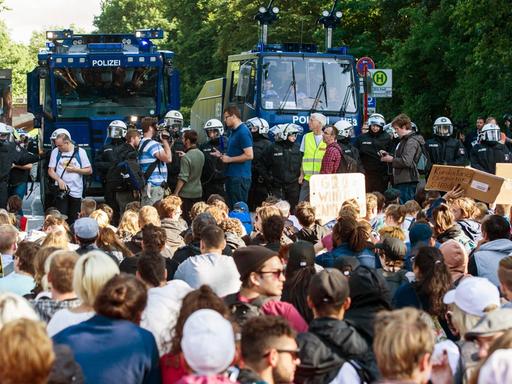 Teilnehmer einer Sitzblockade sitzen am 8. Juli 2017 in Hamburg nach der Demonstration "Grenzenlose Solidarität statt G20" Polizisten mit zwei Wasserwerfern gegenüber. Der G20-Gipfel der Staats-und Regierungschefs fand am 7. und 8. Juli 2017 in Hamburg statt. Bei den Demonstrationen gegen den Gipfel kam es zu schweren Krawallen.