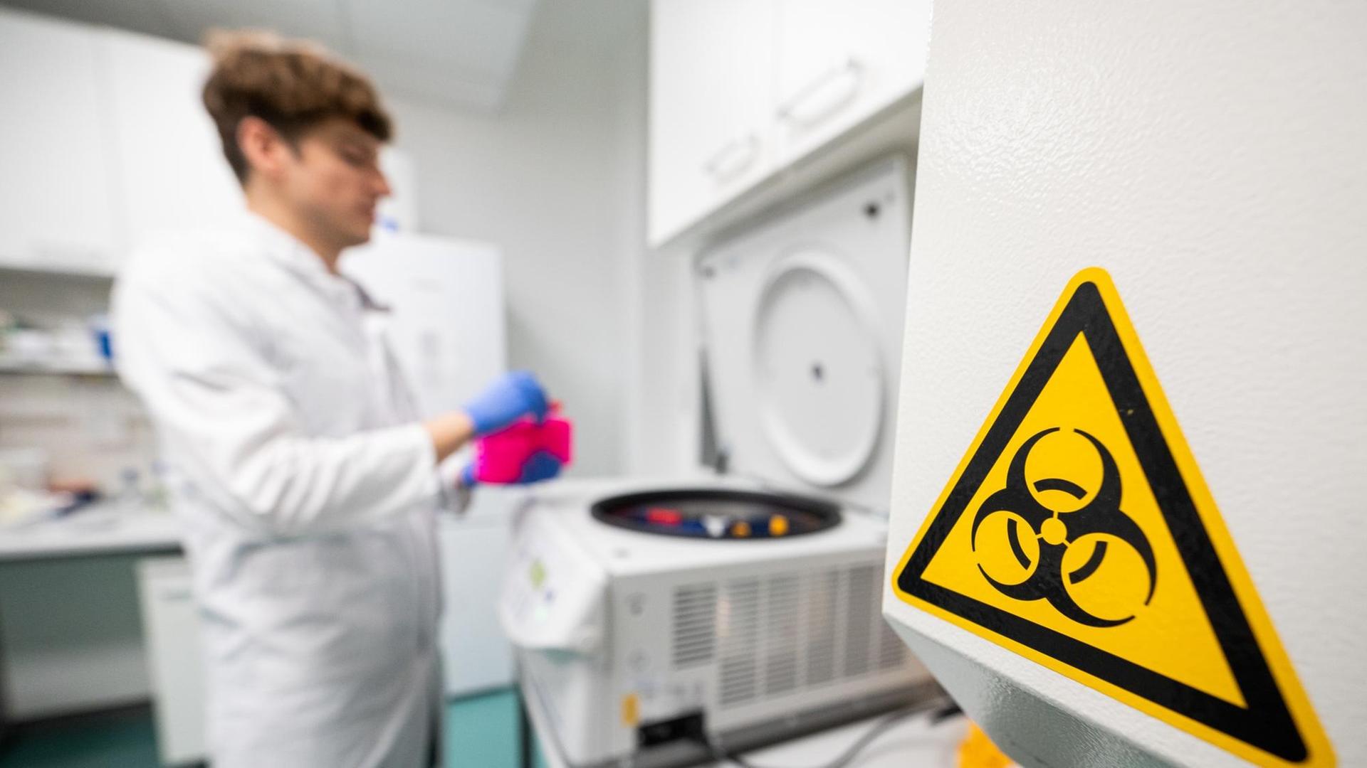 Ein Laborant bestückt eine Zentrifuge im Institut für Virologie an der Charité Berlin Mitte, in dem Untersuchungen zum Corona-Virus laufen.