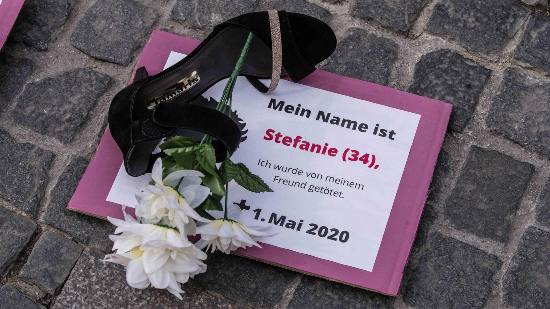 Proteste gegen Femizide: Auf einem Schild steht "Mein Name ist Stefanie (34) ich wurde von meinem Freund getötet". Daneben liegt auf dem Boden ein Schuh und eine weiße Blume. Proteste gegen Femizide: Auf einem Schild steht "Mein Name ist Stefanie (34) ich wurde von meinem Freund getötet". Daneben liegt auf dem Boden ein Schuh und eine weiße Blume.