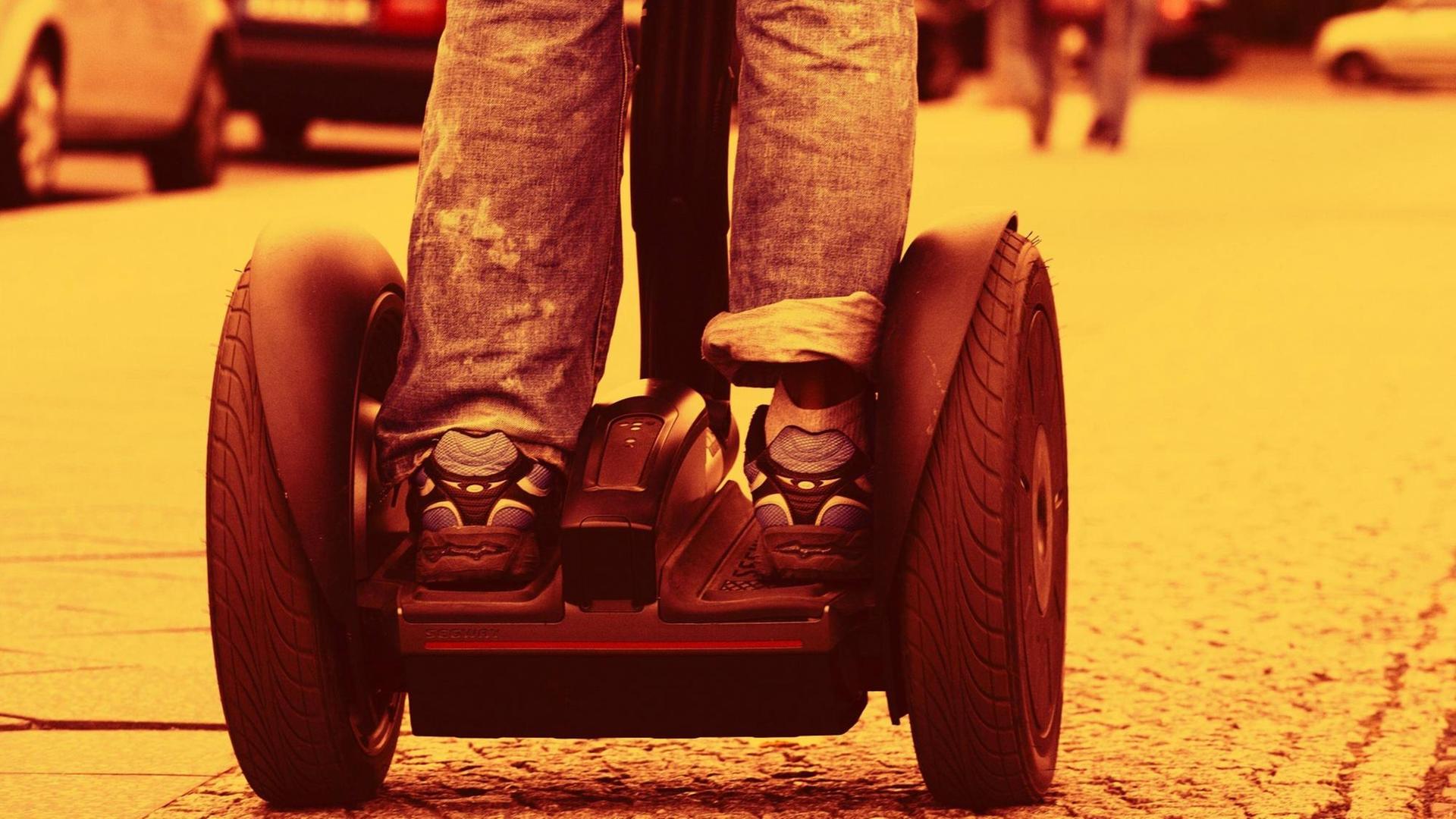 Zwei Beine auf zwei Rädern: Nahaufnahme eines Segway-Rollers. Zwei Beine auf zwei Rädern: Nahaufnahme eines Segway-Rollers.