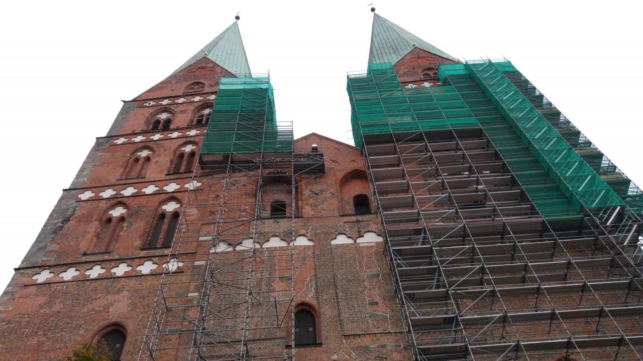 Die eingerüsteten 125 Meter hohen Türme der gotischen Backsteinkirche St. Marien/Lübeck. Die Kathedrale war 1942 im Krieg ausgebrannt und danach wieder aufgebaut worden. Die eingerüsteten 125 Meter hohen Türme der gotischen Backsteinkirche St. Marien/Lübeck. Die Kathedrale war 1942 im Krieg ausgebrannt und danach wieder aufgebaut worden.