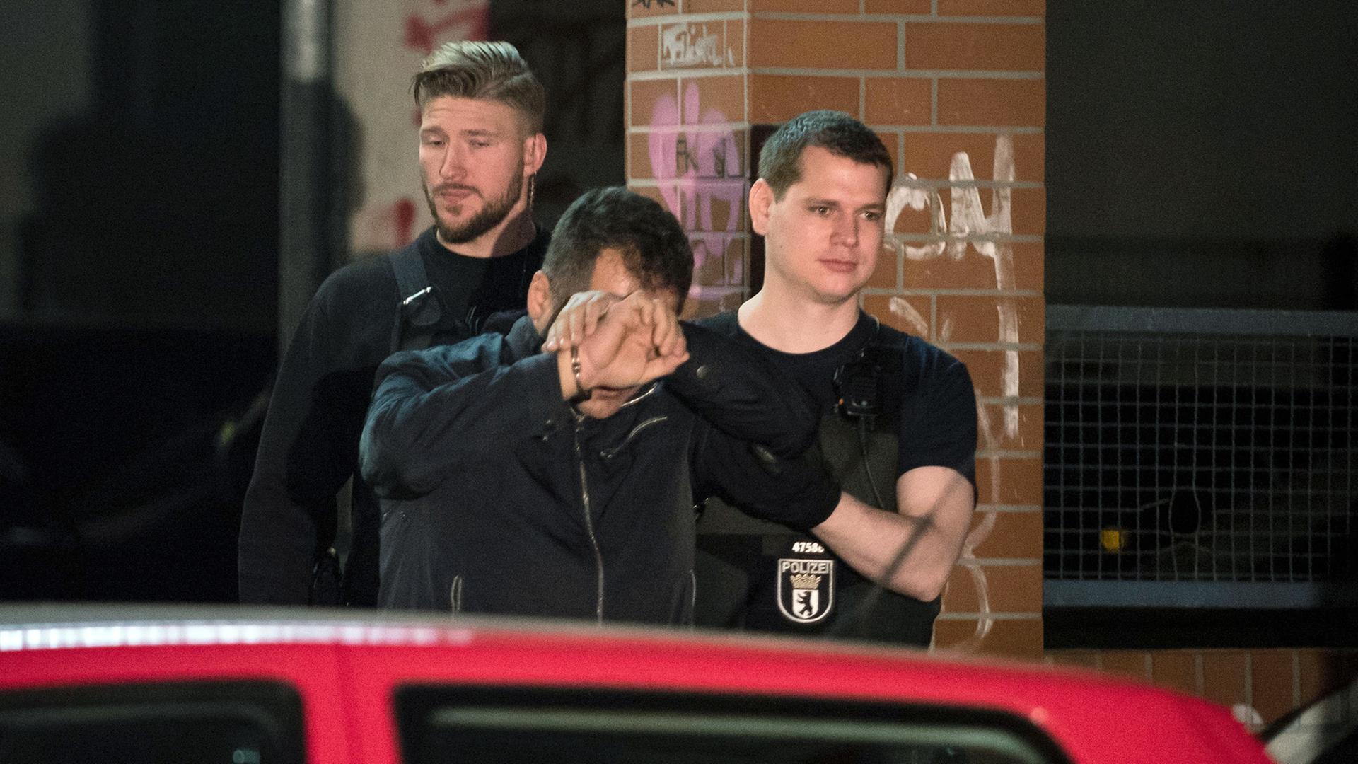 Polizisten führen bei einem Einsatz 2016 eine Person in Handschellen aus einem Haus in Berlin im Bezirk Neukölln im Rahmen eines Großeinsatzes gegen eine mutmaßlich kriminelle arabische Großfamilie. Polizisten führen bei einem Einsatz 2016 eine Person in Handschellen aus einem Haus in Berlin im Bezirk Neukölln im Rahmen eines Großeinsatzes gegen eine mutmaßlich kriminelle arabische Großfamilie.