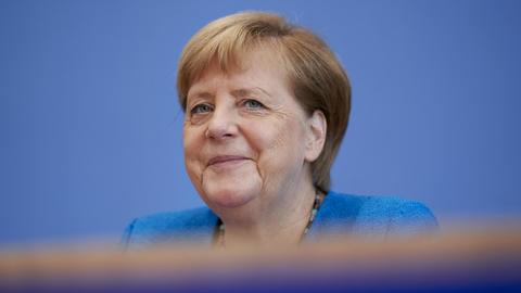 Bundeskanzlerin Angela Merkel vor einem blauen Hintergrund.