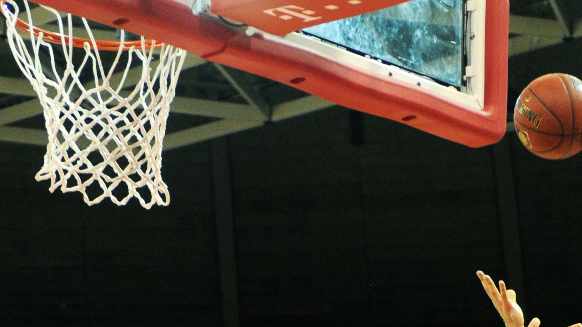 Hände werfen einen Basketball Richtung Korb. Hände werfen einen Basketball Richtung Korb.
