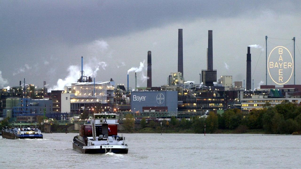Schiffe fahren auf dem Rhein am Chemie- und Pharmakonzern Bayer in Leverkusen vorbei. Schiffe fahren auf dem Rhein am Chemie- und Pharmakonzern Bayer in Leverkusen vorbei.