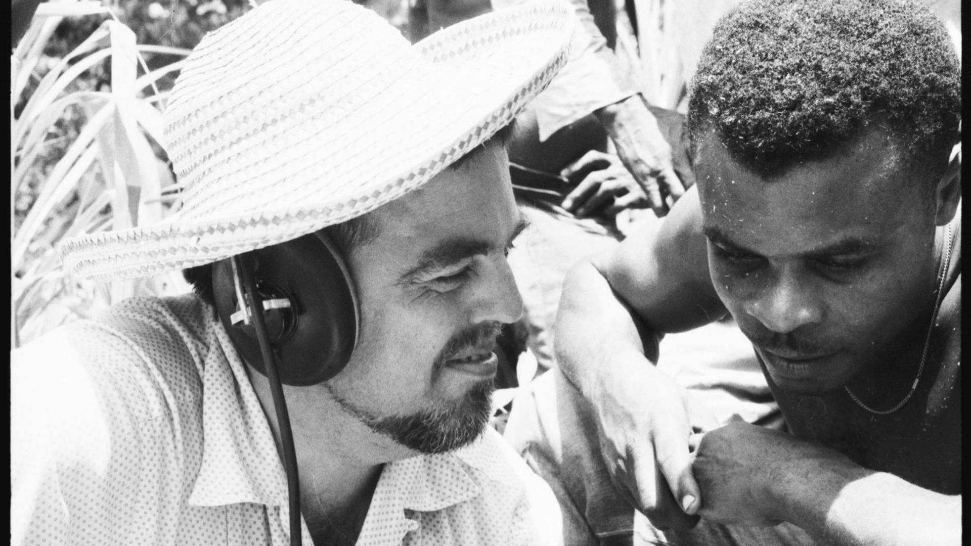 Alan Lomax (links) und Musiker während des Abhörens einer Aufnahme in der Karibik. Alan Lomax trägt Kopfhörer Alan Lomax (links) und Musiker während des Abhörens einer Aufnahme in der Karibik. Alan Lomax trägt Kopfhörer