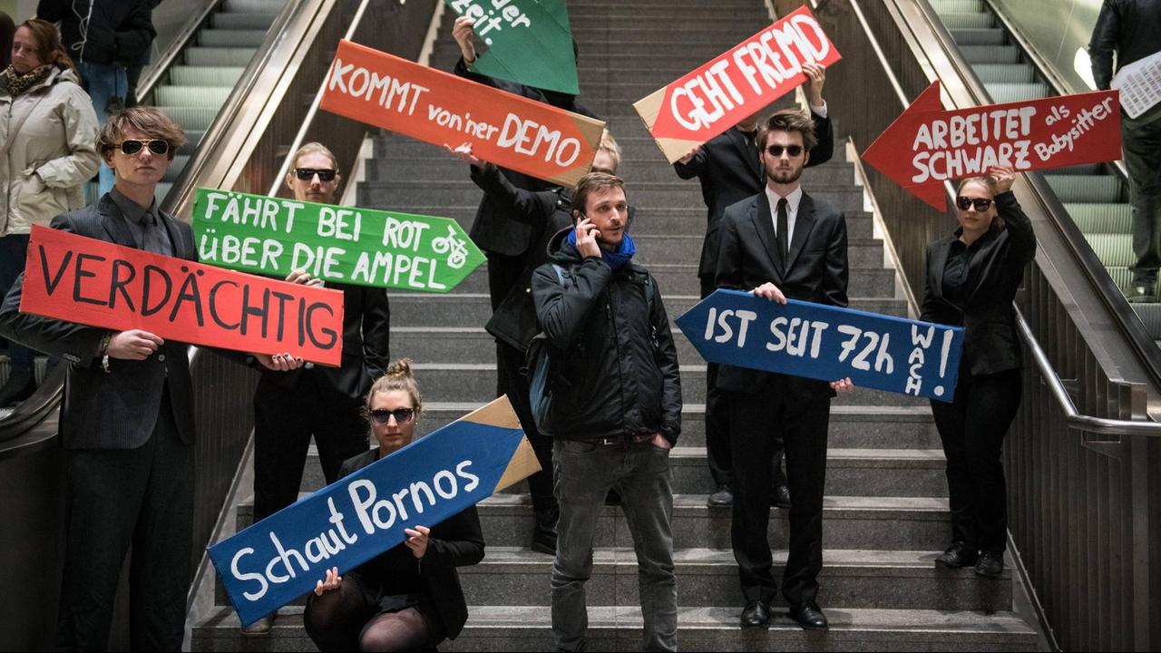 Demonstranten halten Schilder mit Aufschriften wie "geht fremd", "Schaut Pornos", "fährt über die rote Ampel". Aktion gegen den Ausbau von Videoüberwachung im öffentlichen Raum am Bahnhof Südkreuz in Berlin am 27.11.2017. Demonstranten halten Schilder mit Aufschriften wie "geht fremd", "Schaut Pornos", "fährt über die rote Ampel". Aktion gegen den Ausbau von Videoüberwachung im öffentlichen Raum am Bahnhof Südkreuz in Berlin am 27.11.2017.