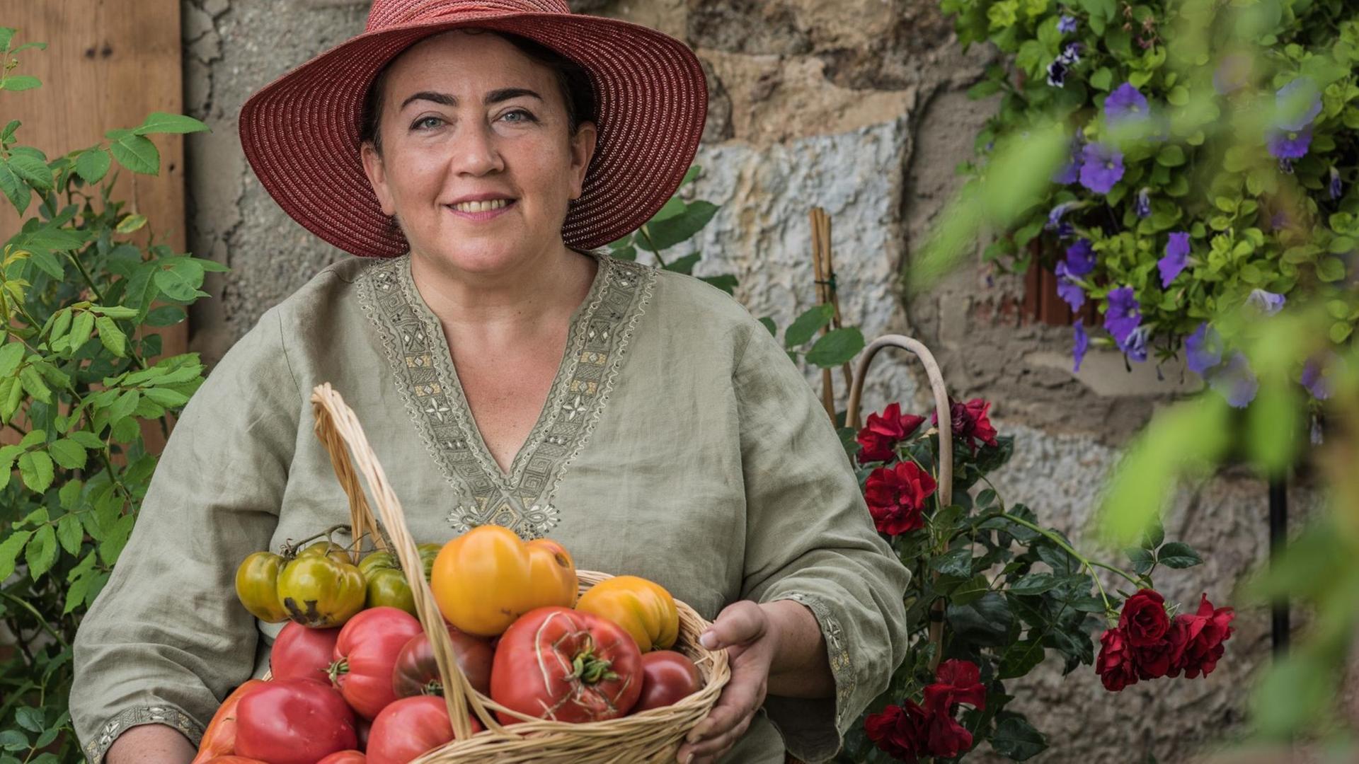 Irina Zacharias mit einem Korb voller Tomaten, über 1000 Tomatensorten zieht Zacharias auf.