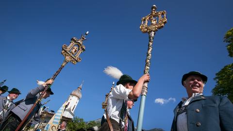 Katholiken ziehen mit ihren Trachten, bunt bestickten Fahnen und prächtig geschmückten Altären anlässlich der Fronleichnamsprozession durch Garmisch-Partenkirchen