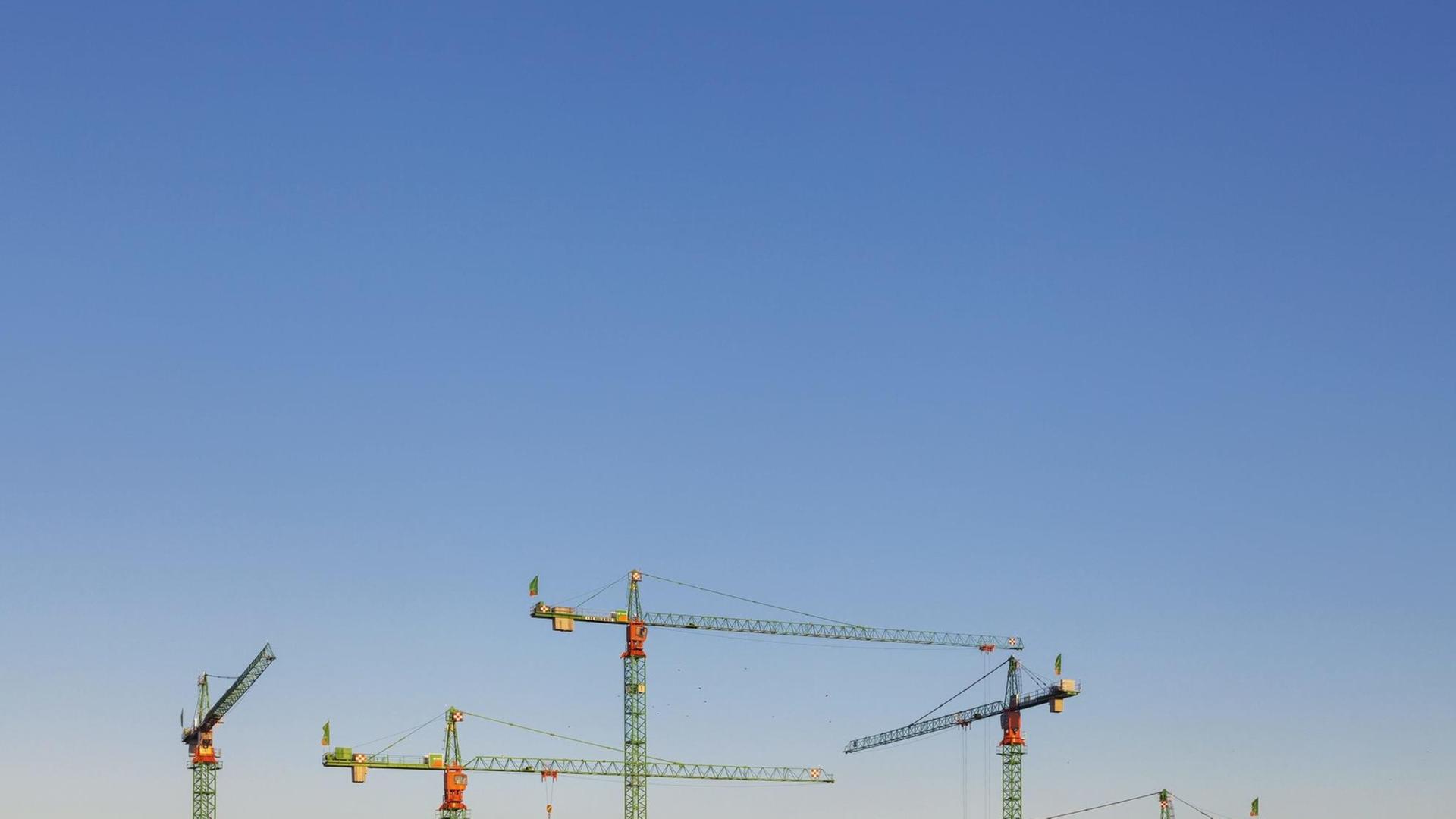 Baukräne in Berlin recken sich in den blauen Himmel. Baukräne in Berlin recken sich in den blauen Himmel.