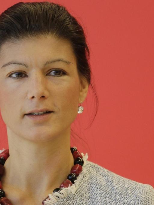 Sahra Wagenknecht vor rotem Hintergrund.