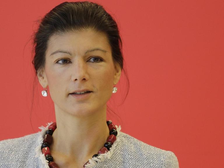 Sahra Wagenknecht vor rotem Hintergrund.
