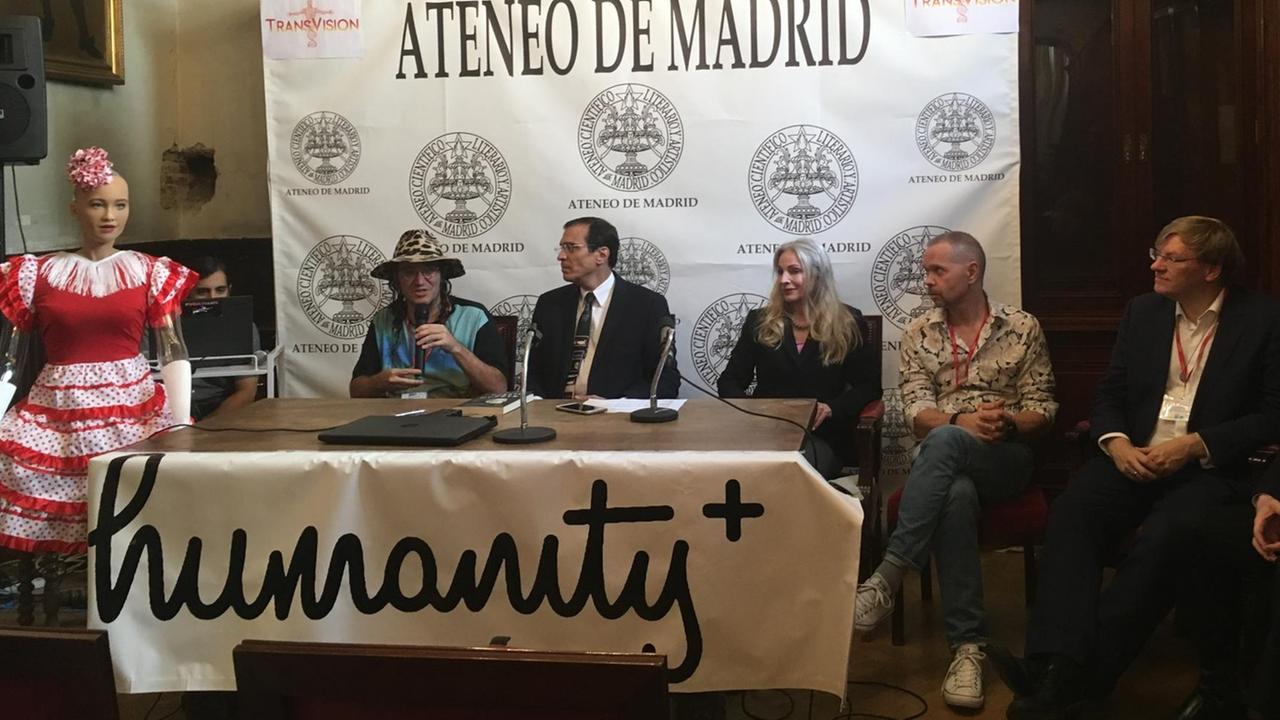 Bei der Pressekonferenz zur Eröffnung der TransVision 2018 wurde auch der der humanoide Roboter "Sophia" vorgestellt. Daneben sitzen von links nach rechts Ben Goertzel, José Luis Cordeiro, Natasha Vita-More, Michael Greve und Anders Sandberg. Bei der Pressekonferenz zur Eröffnung der TransVision 2018 wurde auch der der humanoide Roboter "Sophia" vorgestellt. Daneben sitzen von links nach rechts Ben Goertzel, José Luis Cordeiro, Natasha Vita-More, Michael Greve und Anders Sandberg.
