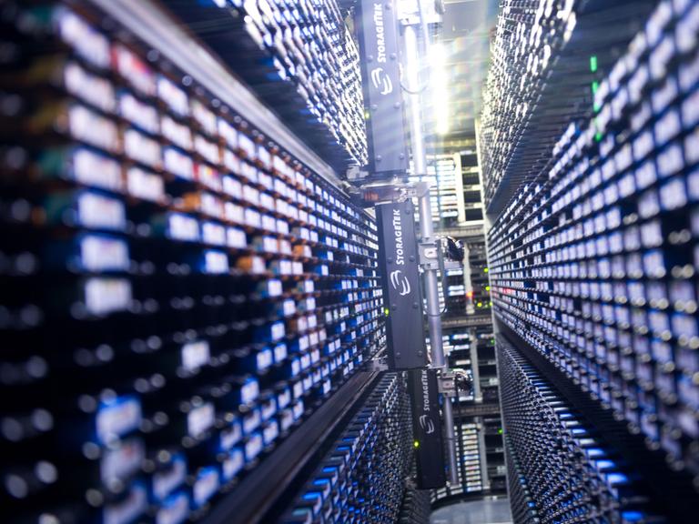 Lange Reihen von Lichtern laufen in der Mitte des Bildes zusammen. Es zeigt ein automatisches Lager für Magnet-Datenbänder in einem Nebenraum des Supercomputers "Blizzard" im Deutschen Klimarechenzentrum in Hamburg