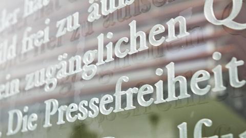 Das Wort Pressefreiheit ist in einem Ausschnitt des Artikels 5 des Grundgesetzes auf einer Glasscheiben am Außenhof des Jakob-Kaiser-Hauses in Berlin zu sehen.