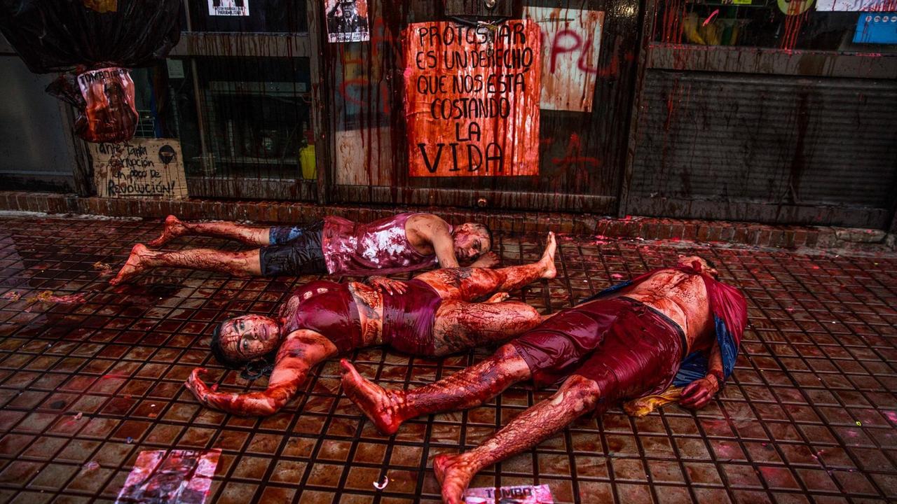 In der kolumbianischen Stadt Bogoto Cundinamarca hat sich ein Künstlertrio zum Protest gegen Polizeigewalt in einem der Supermärkte vor eine Filiale der Supermarktkette gelegt und sich mit roter Farbe beschmiert, die wie Blut aussieht.