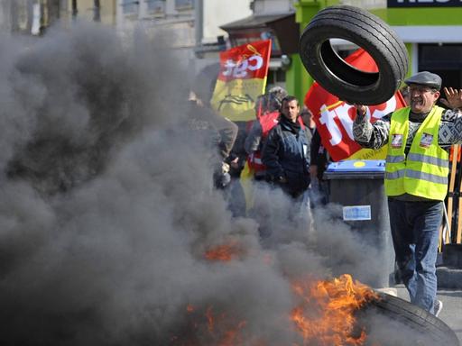 Streikende haben die Zufahrt zu einer Straße mit brennenden Autoreifen blockiert, um gegen die Arbeitsmarkt-Reform der französischen Regierung zu protestieren.