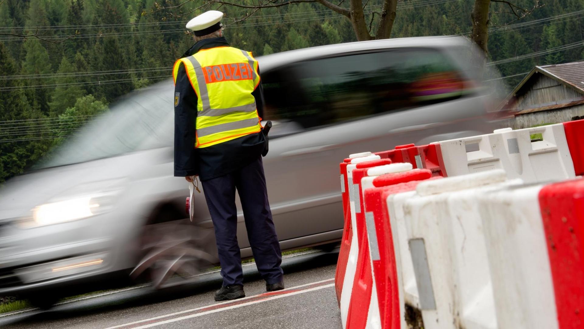 Ein Polizist kontrolliert am Grenzübergang in Mittenwald (Bayern) die von Österreich nach Deutschland einreisenden Autos. Ein Polizist kontrolliert am Grenzübergang in Mittenwald (Bayern) die von Österreich nach Deutschland einreisenden Autos.