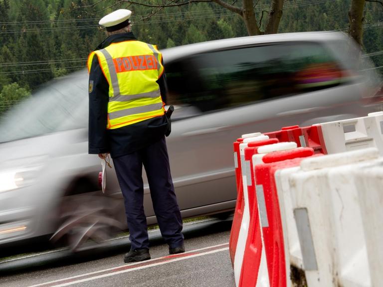 Ein Polizist kontrolliert am Grenzübergang in Mittenwald (Bayern) die von Österreich nach Deutschland einreisenden Autos.