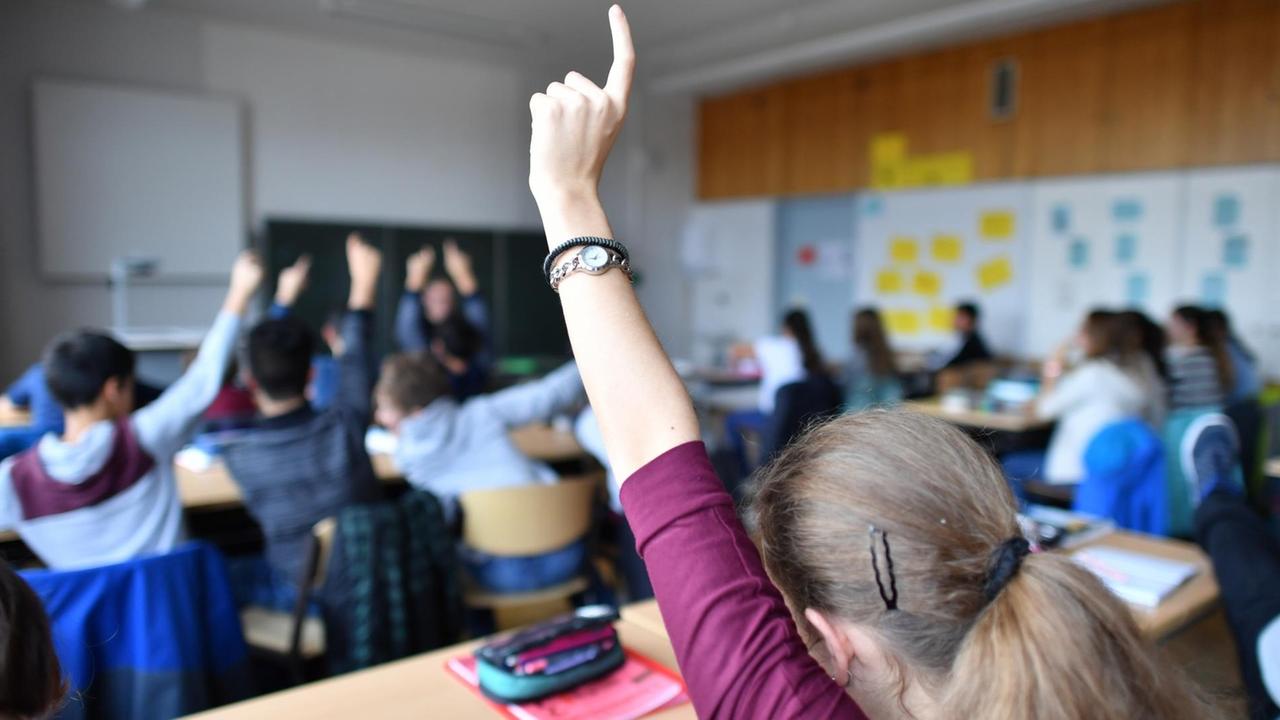 Siebtklässler strecken am 23.11.2016 während des Deutschunterrichts in einem Gymnasium in Friedrichshafen (Baden-Württemberg) ihre Hände nach oben. Siebtklässler strecken am 23.11.2016 während des Deutschunterrichts in einem Gymnasium in Friedrichshafen (Baden-Württemberg) ihre Hände nach oben.